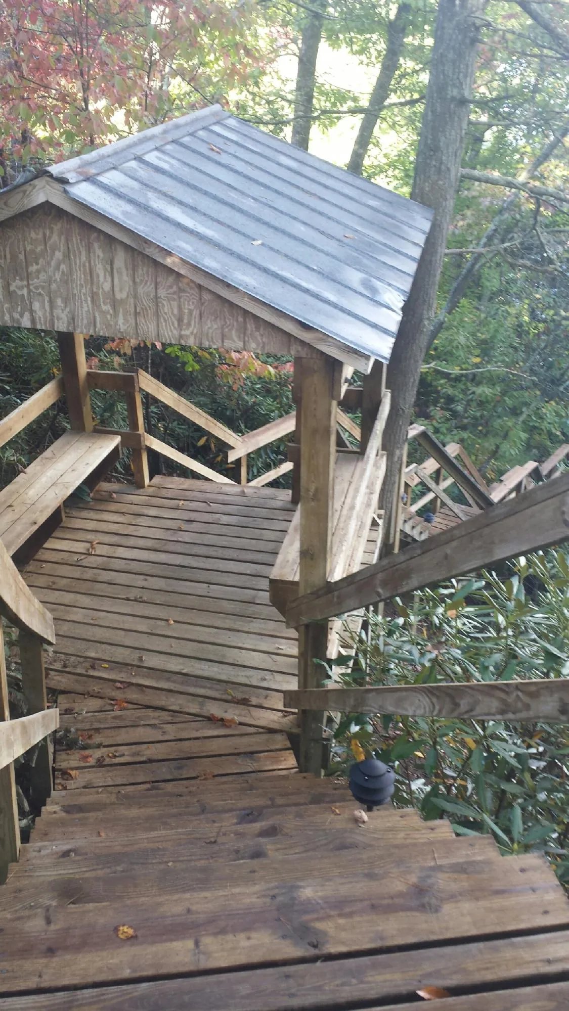 Metal roofed shelter over wooden steps on a wooded walkway — Skylight Repair & Installation work by our crew in Lake George