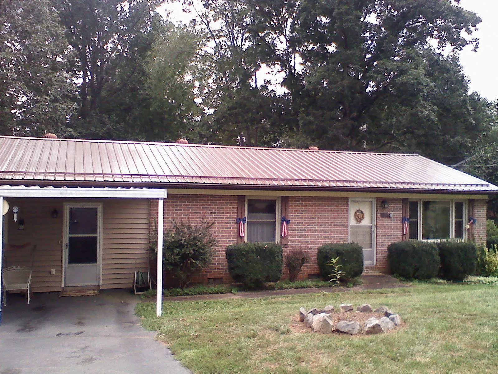 Bronze metal roof and carport on a brick ranch home — Roof Repair work by our crew in Lake George